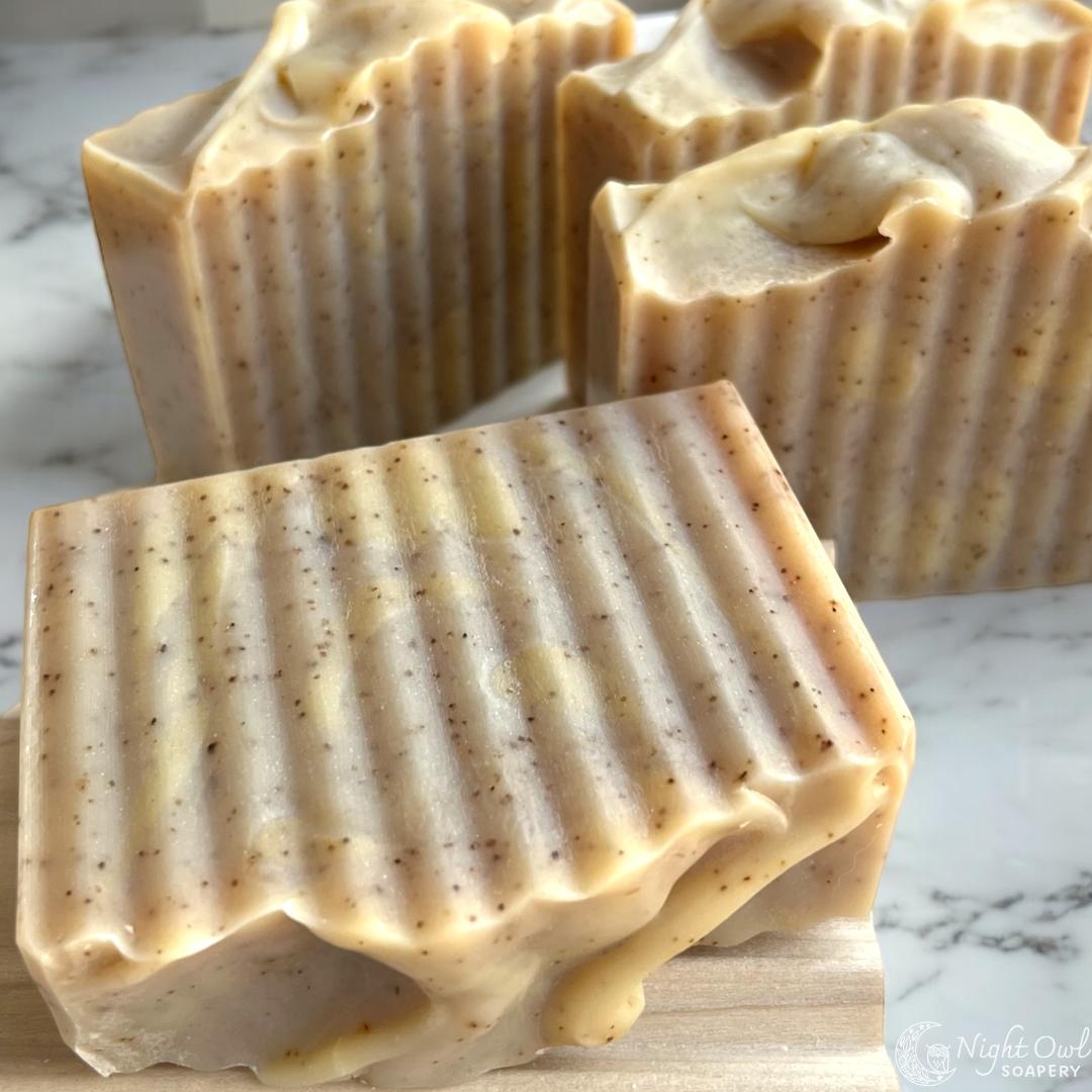 Three bars of wavy cut soap with speckles from natural banana on a marble background