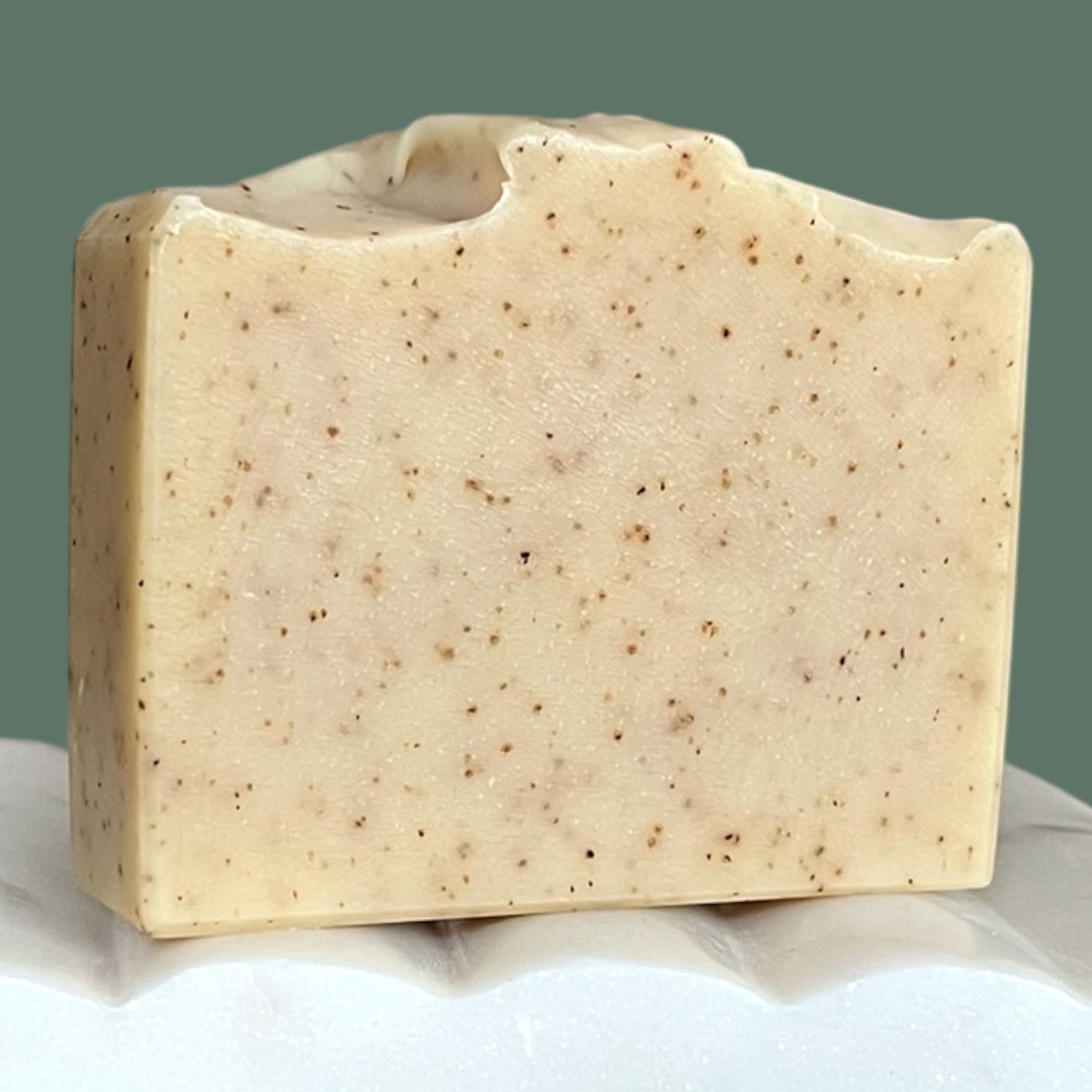 Bar of soap with a speckled texture surface with green background