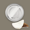 Coconut cream jar with a slice of coconut on a brown background