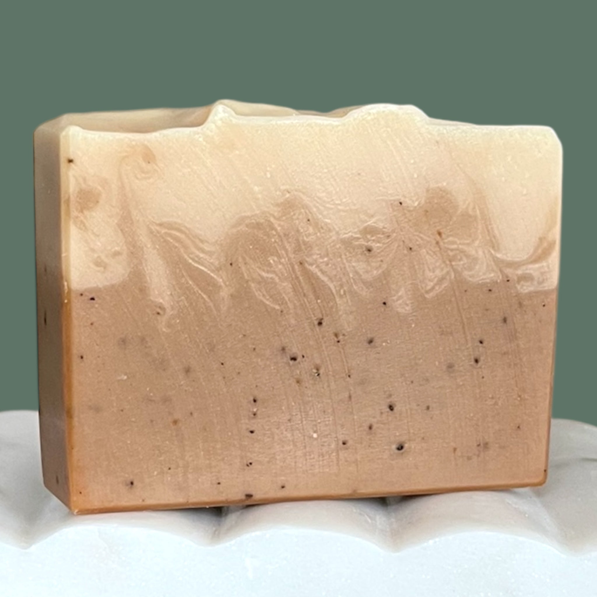 Bar of brown and white soap with natural texture on a white background