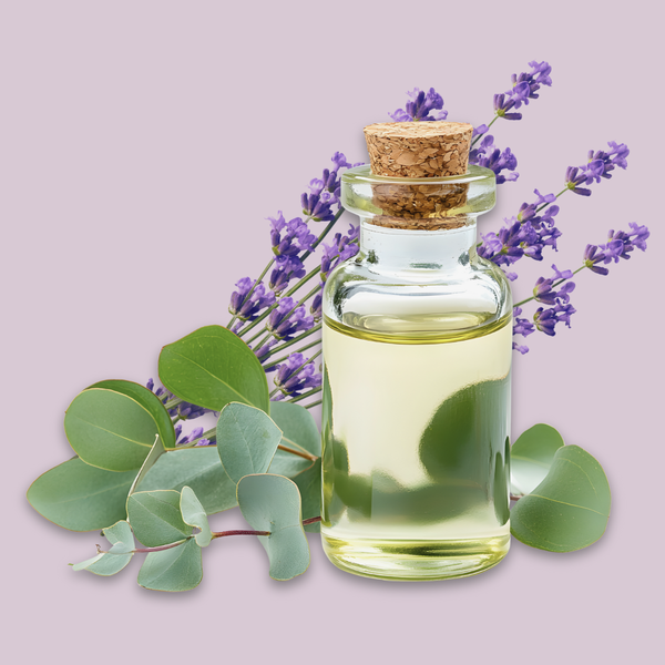 Glass bottle with cork lid containing essential oil, surrounded by lavender flowers and eucalyptus leaves on a light purple background.
