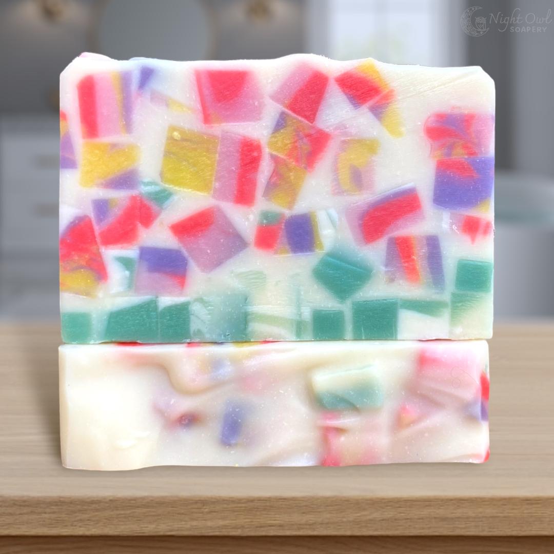 Colorful mosaic soap bar on a wooden surface with a blurred background
