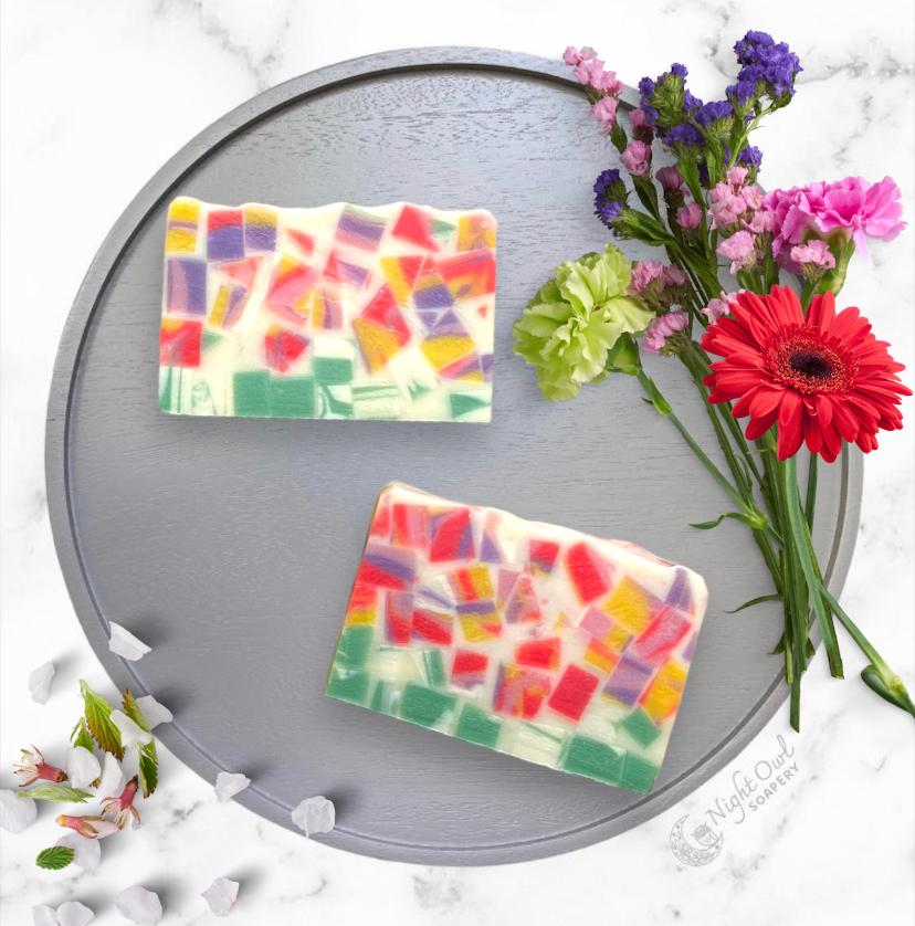 Colorful soap bars on a gray tray with flowers