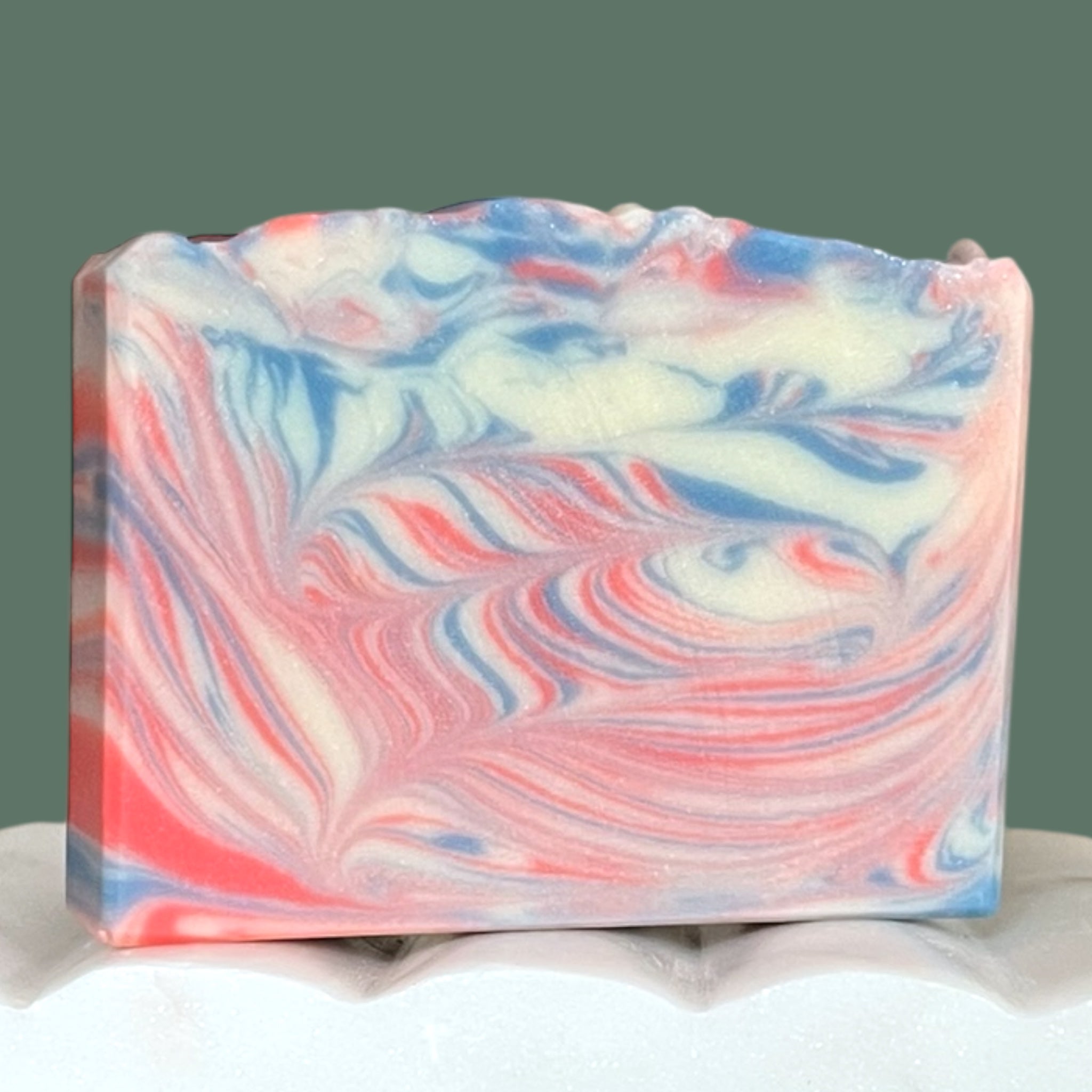 Marbled soap bar with red, white and blue colors on a green background