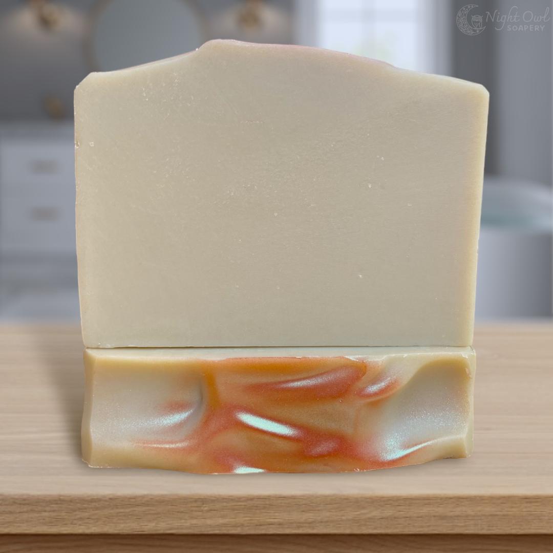Bars of green tea soap stacked on a wooden surface