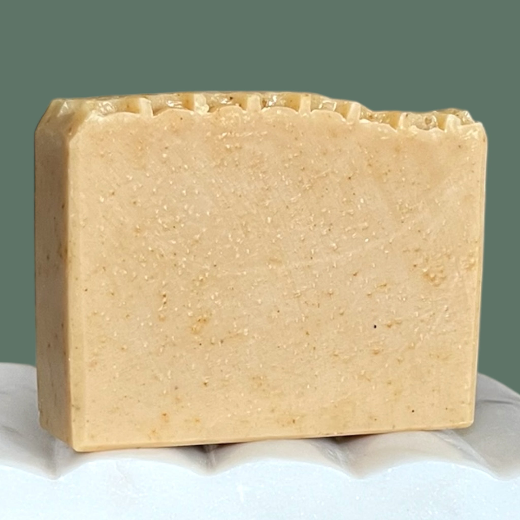 Bar of beige soap with a honeycomb textured top with a green background