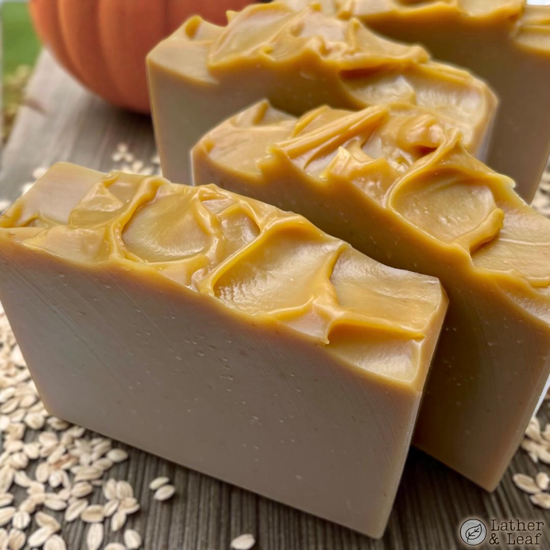 pumpkin spice oatmeal soap bars on a table with a pumpkin and scattered oats
