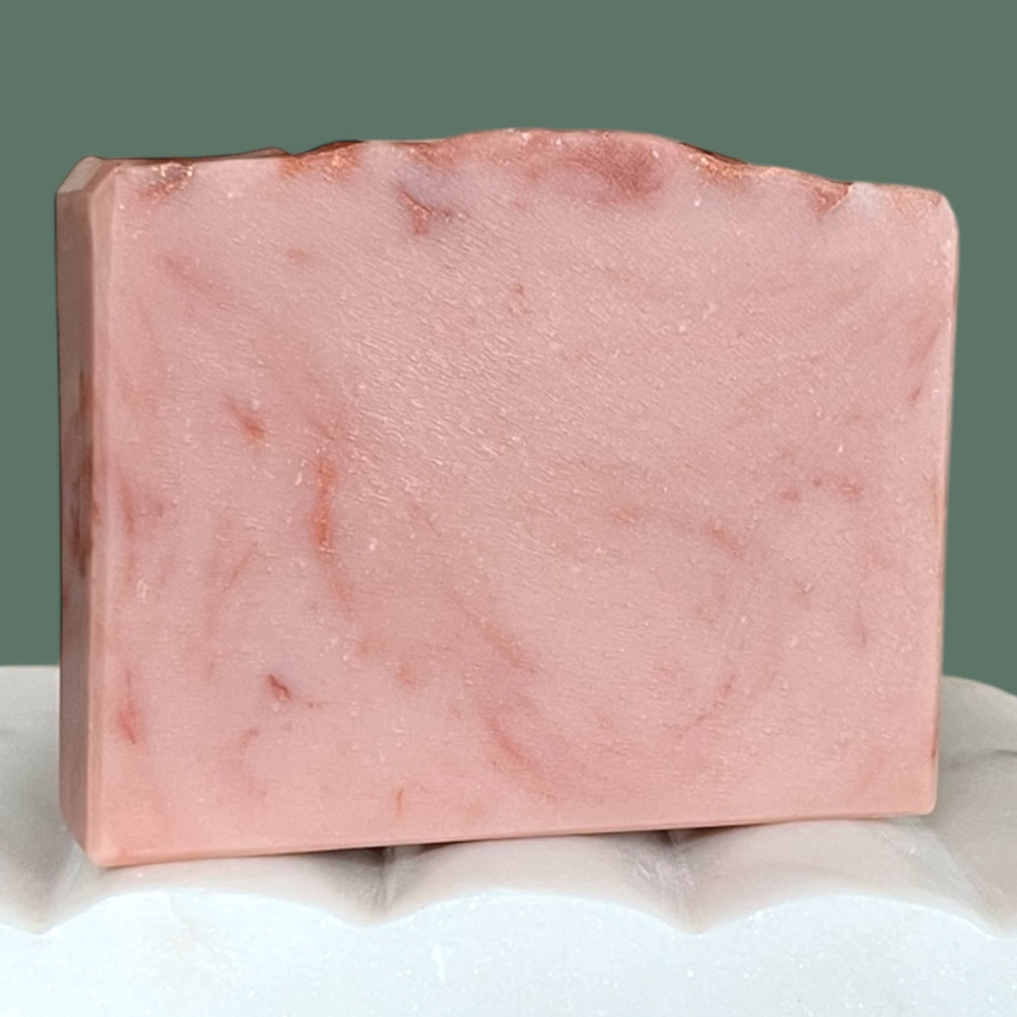 Pink mauve marbled soap bar on a white surface with a gray background