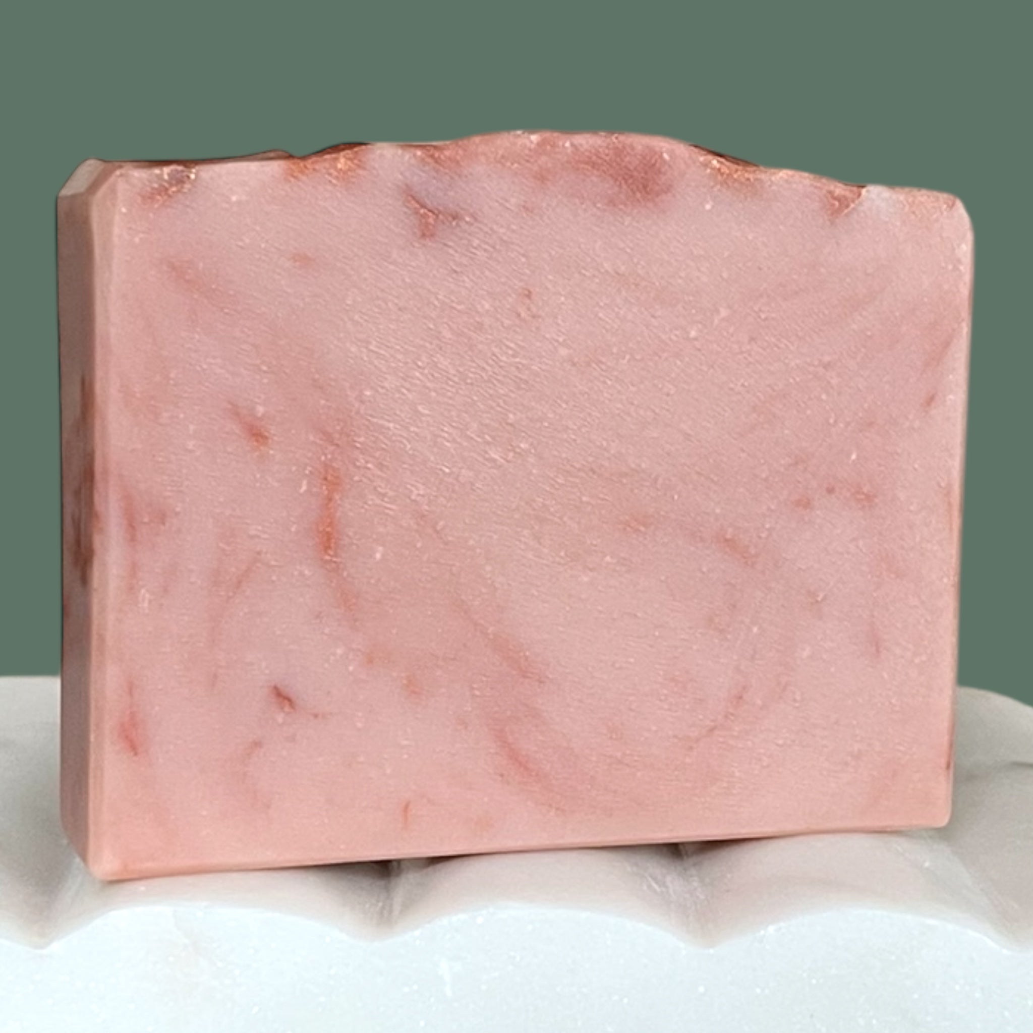 Pink mauve marbled soap bar on a white surface with a gray background