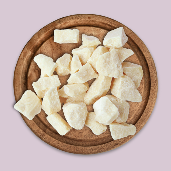 Wooden plate with chunks of Sal Butter on a light pink background