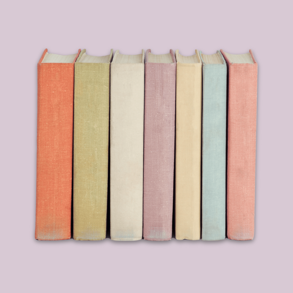 Row of books with colorful spines on a light purple background