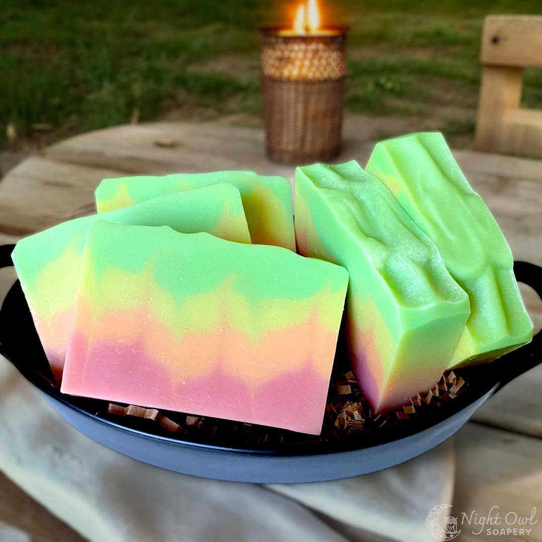 Colorful soap bars in a black bowl with a blurred outdoor background