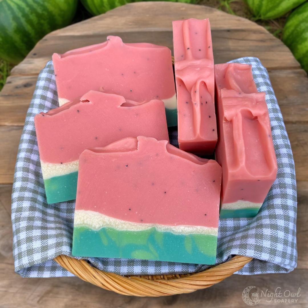 Watermelon-themed soap bars on a checkered cloth with a natural background