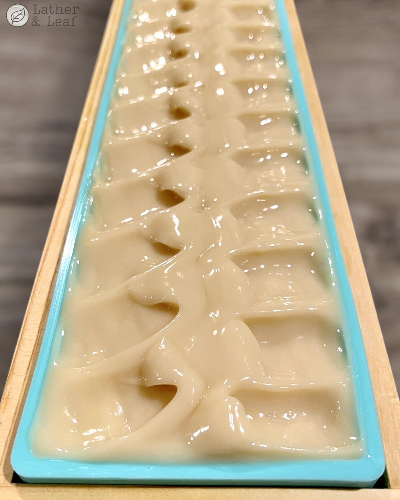 Just poured batch of coconut soap in a silicone mold with 'Lather & Leaf' branding.