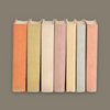 Row of books with cloth covers in various pastel colors on a matching background