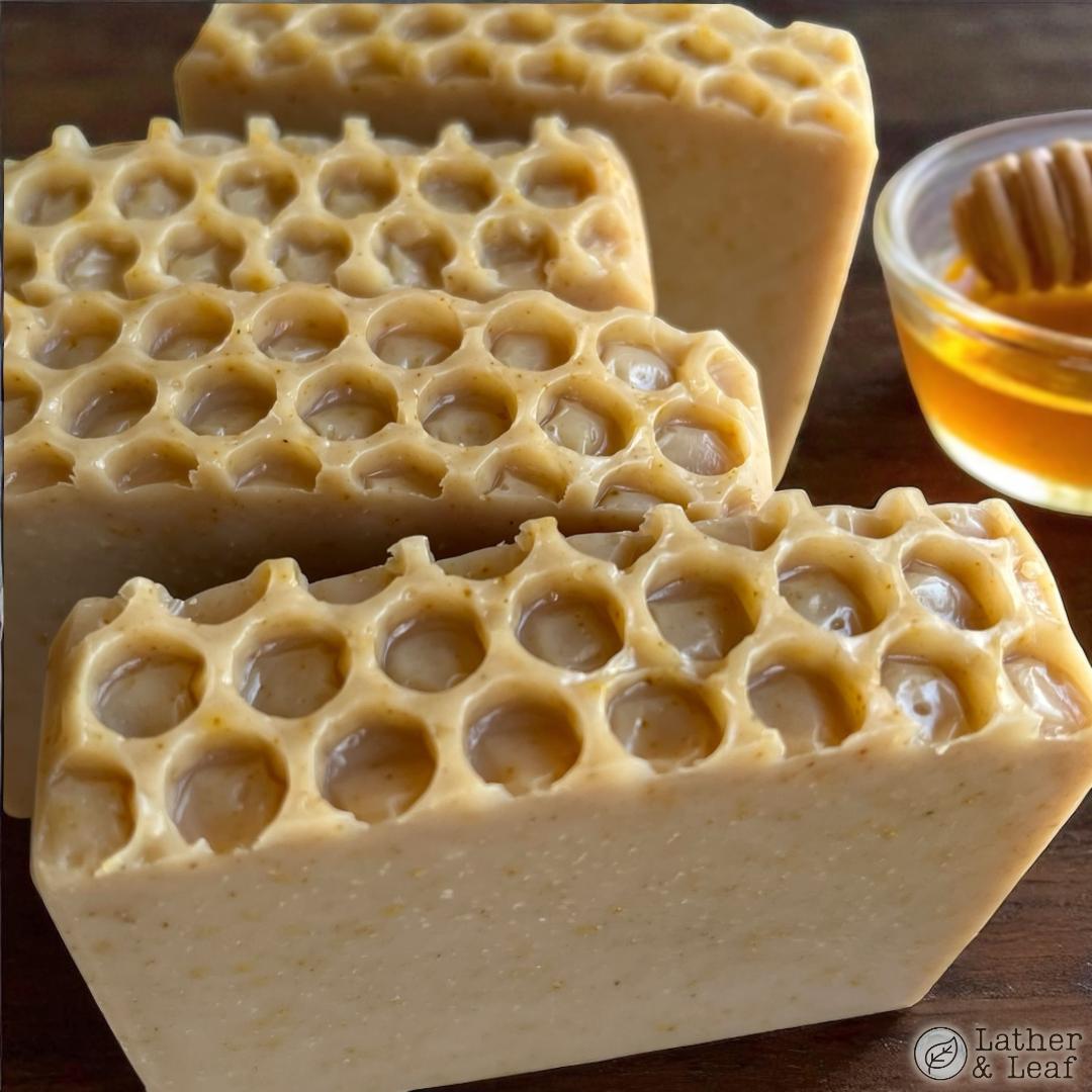 top view of the buzz soap bars with honeycomb textured tops next to a honey dipper 